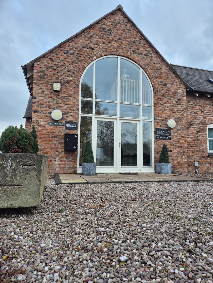 Exterior view of Houlbrook Physiotherapy located at The Coach House in Tarporley, featuring a professional brick building with a large arched window and clear signage.